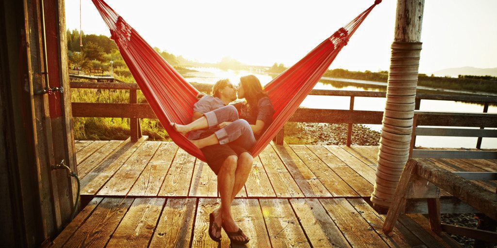 Husband and wife couple kissing in hammock
