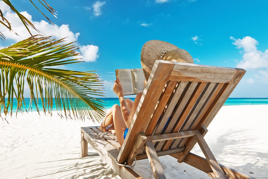 Young woman reading a book at the beach