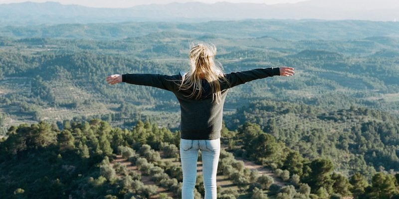 800x400-woman-standing-cliff-arms