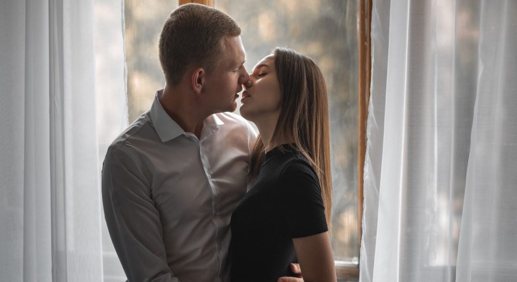 Bozkávajúci sa pár pri okne