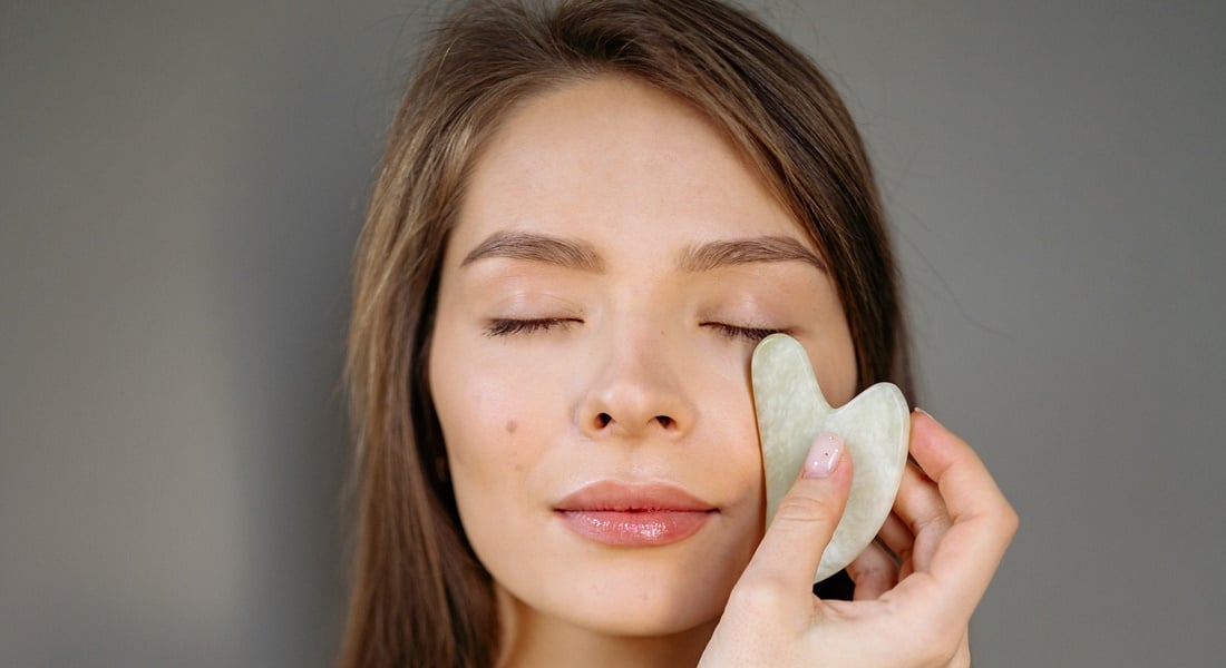 Mladá žena používa gua sha kameň