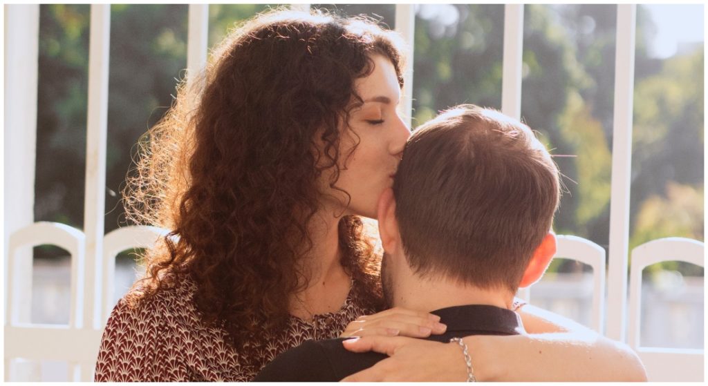 Žena dáva mužovi bozk na hlavu