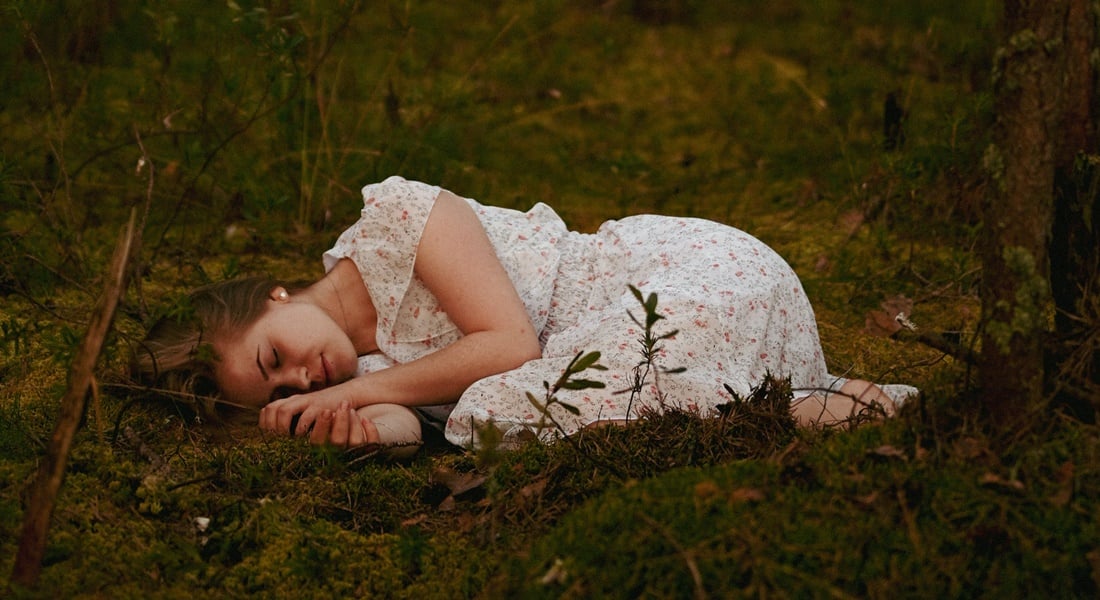 Žena leží na tráve a necíti sa psychicky dobre