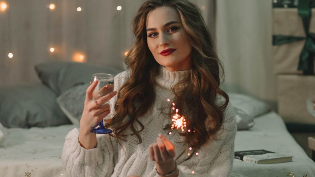 žena na posteli si čítala horoskop