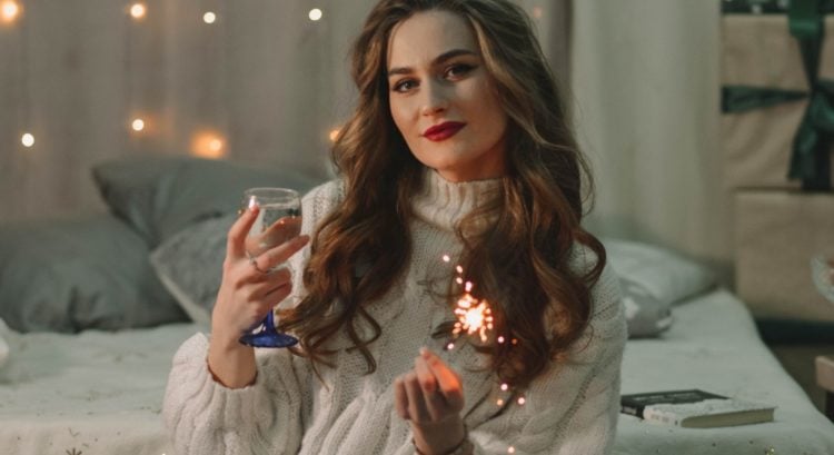žena na posteli si čítala horoskop