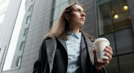 Žena kráča a drží v rukách kávu