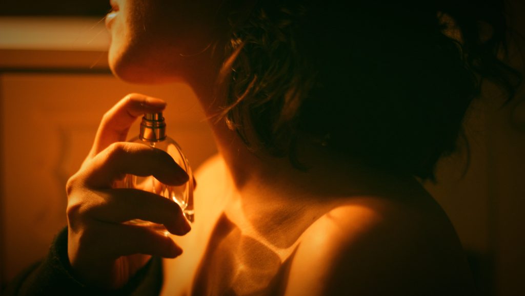 Žena si strieka parfum na krk