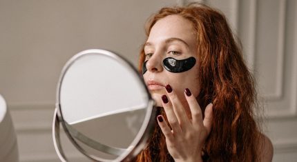 Ryšavá žena sa pozerá do zrkadla