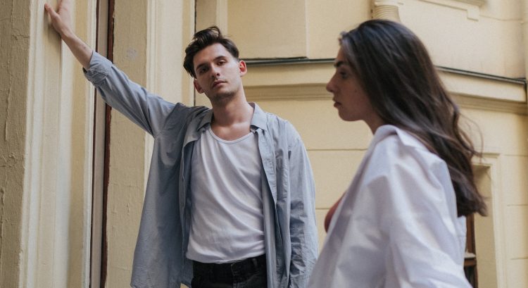 Muž sa opiera o stenu a žena stojí vedľa neho