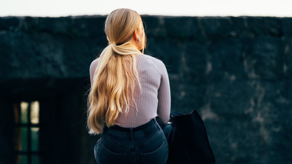 Žena sedí otočená chrbtom