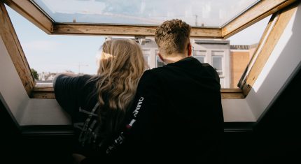 Muž so ženou stoja pri okne