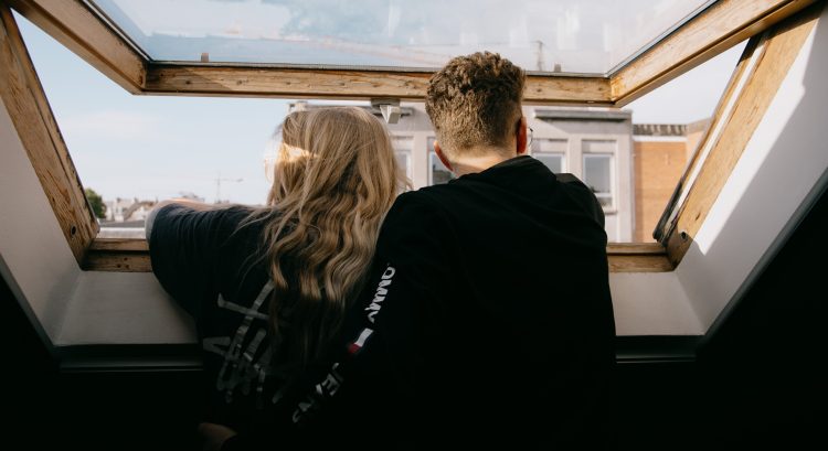 Muž so ženou stoja pri okne