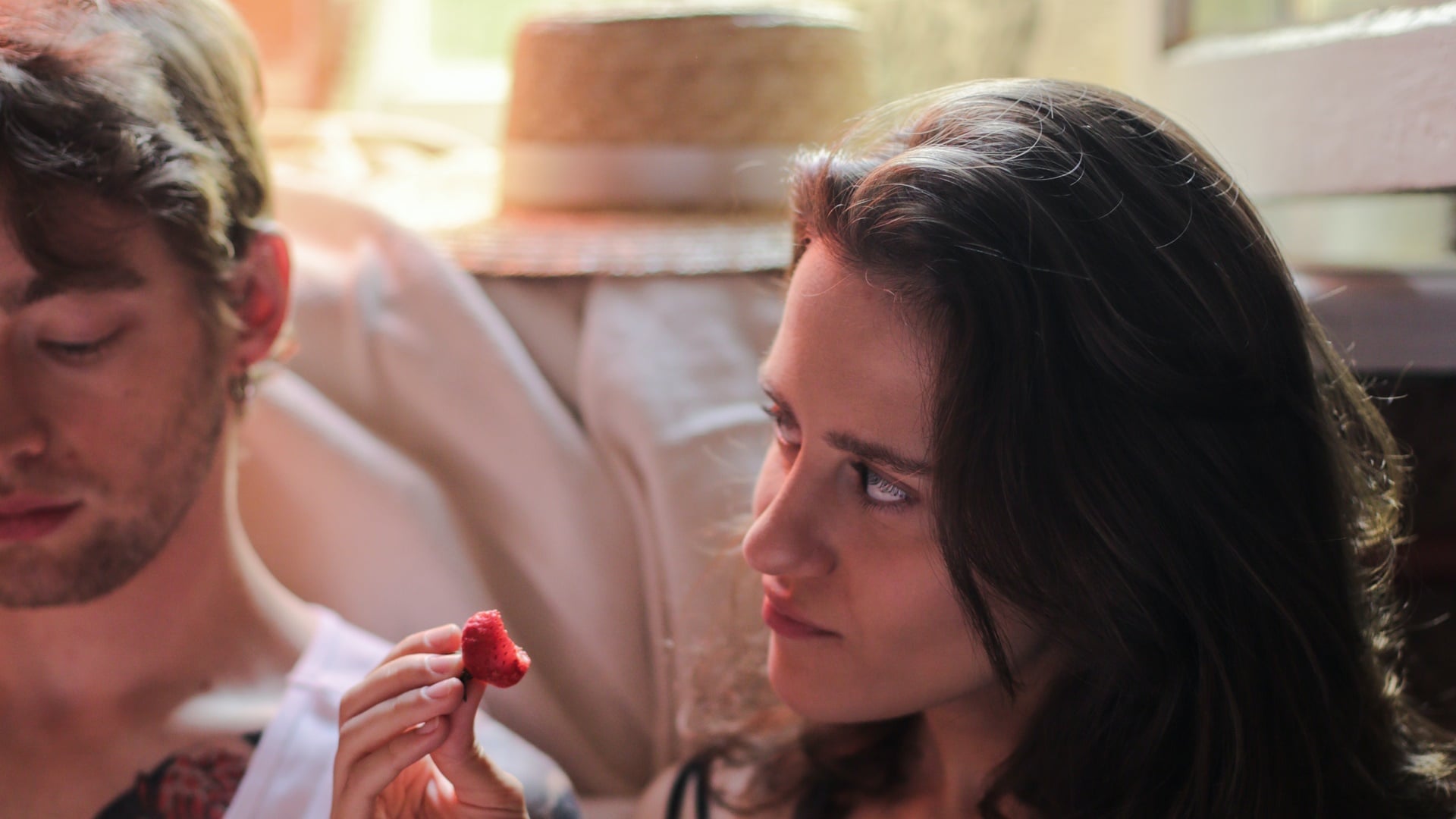 Žena pozerá na muža a je jahodu