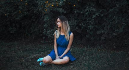 dievča sedí na tráve