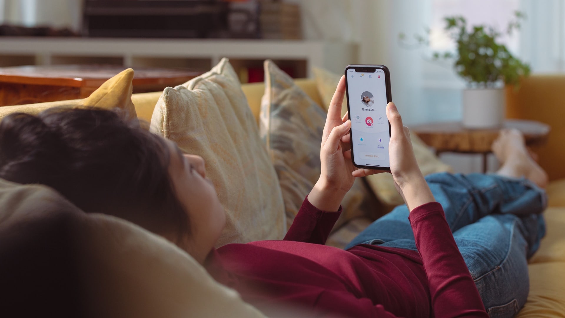 Žena leží na gauči s mobilom v ruke