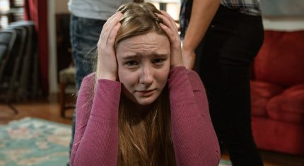 Žena si zakrýva uši pred hádkou