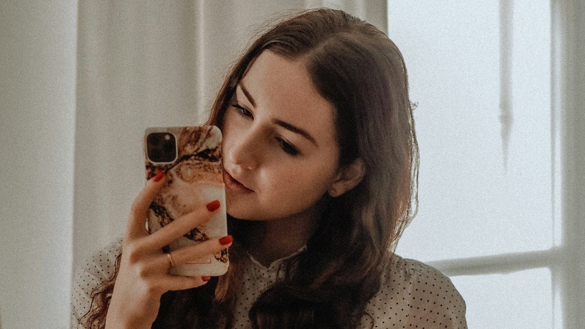 Mladá žena pozerá do mobilu