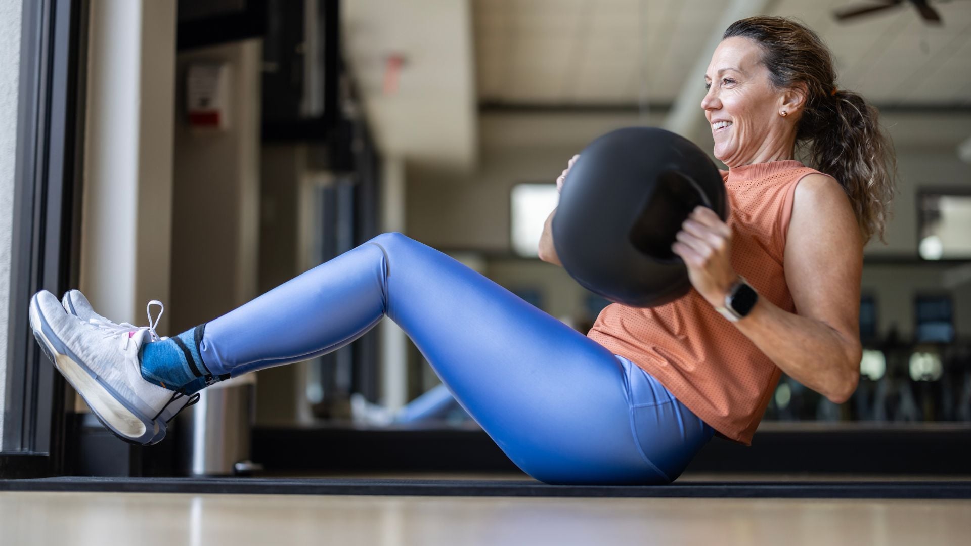 Žena cvičí Russian twist na fitness podložke