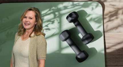 Liz Earle on a yoga mat next to dumbbells